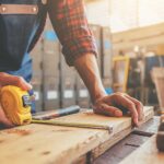 a person measuring a piece of wood for diy wood projects