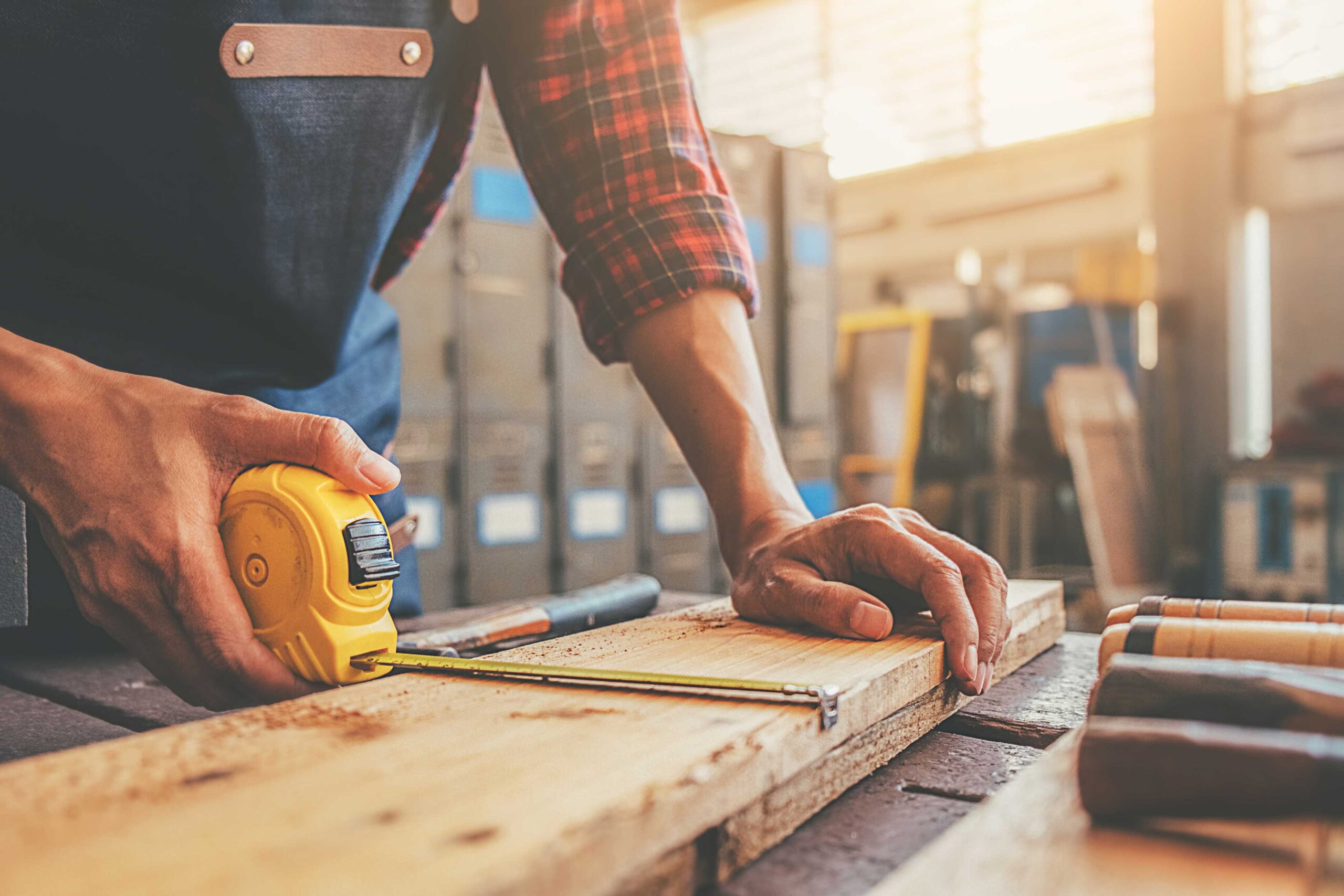 a person measuring a piece of wood for diy wood projects