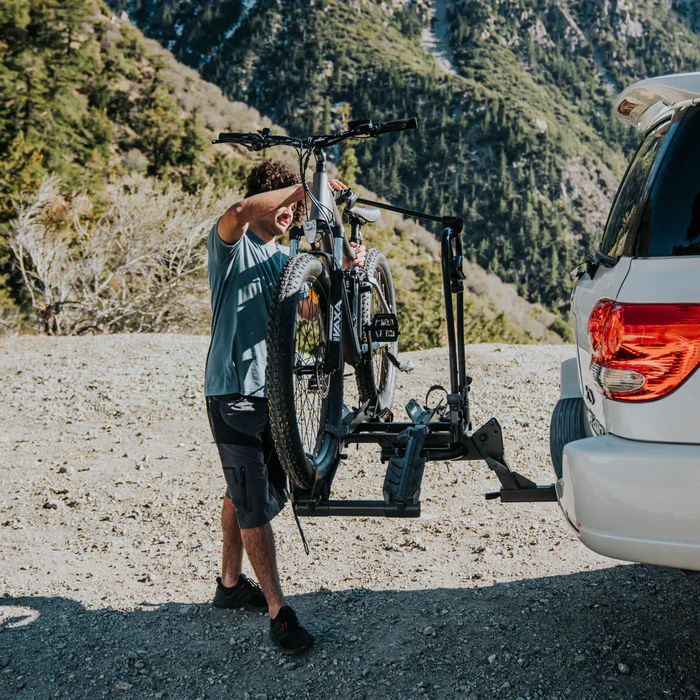 a man holding a bicycle on a rack