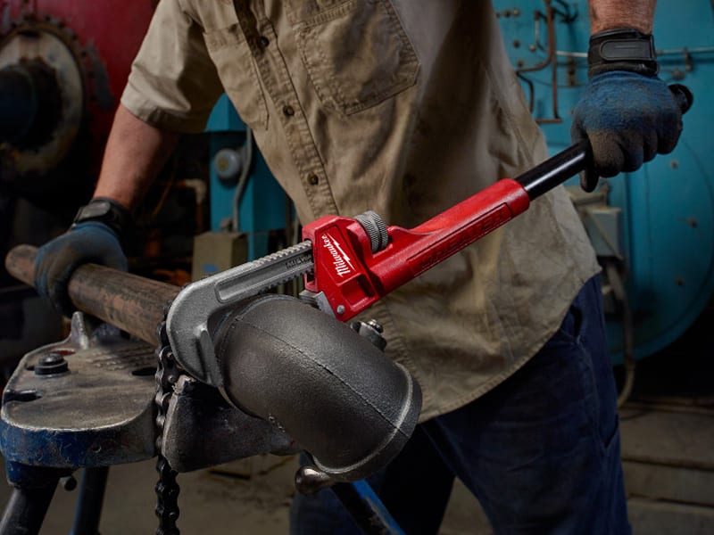 a man holding a pipe wrenches