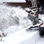 man with cordless snow blowers