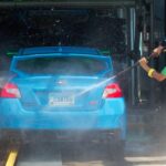 a person washing a car with Touchless Car Washes tools