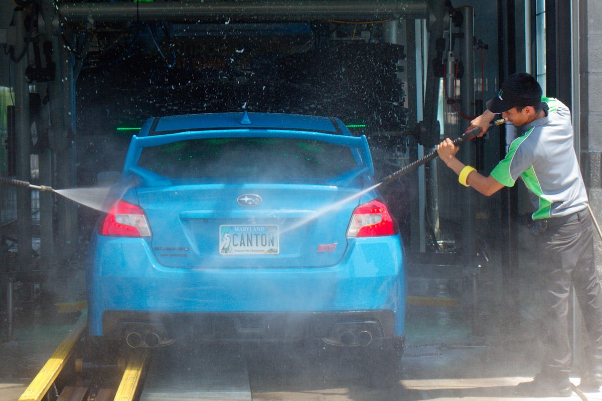 a person washing a car with Touchless Car Washes tools