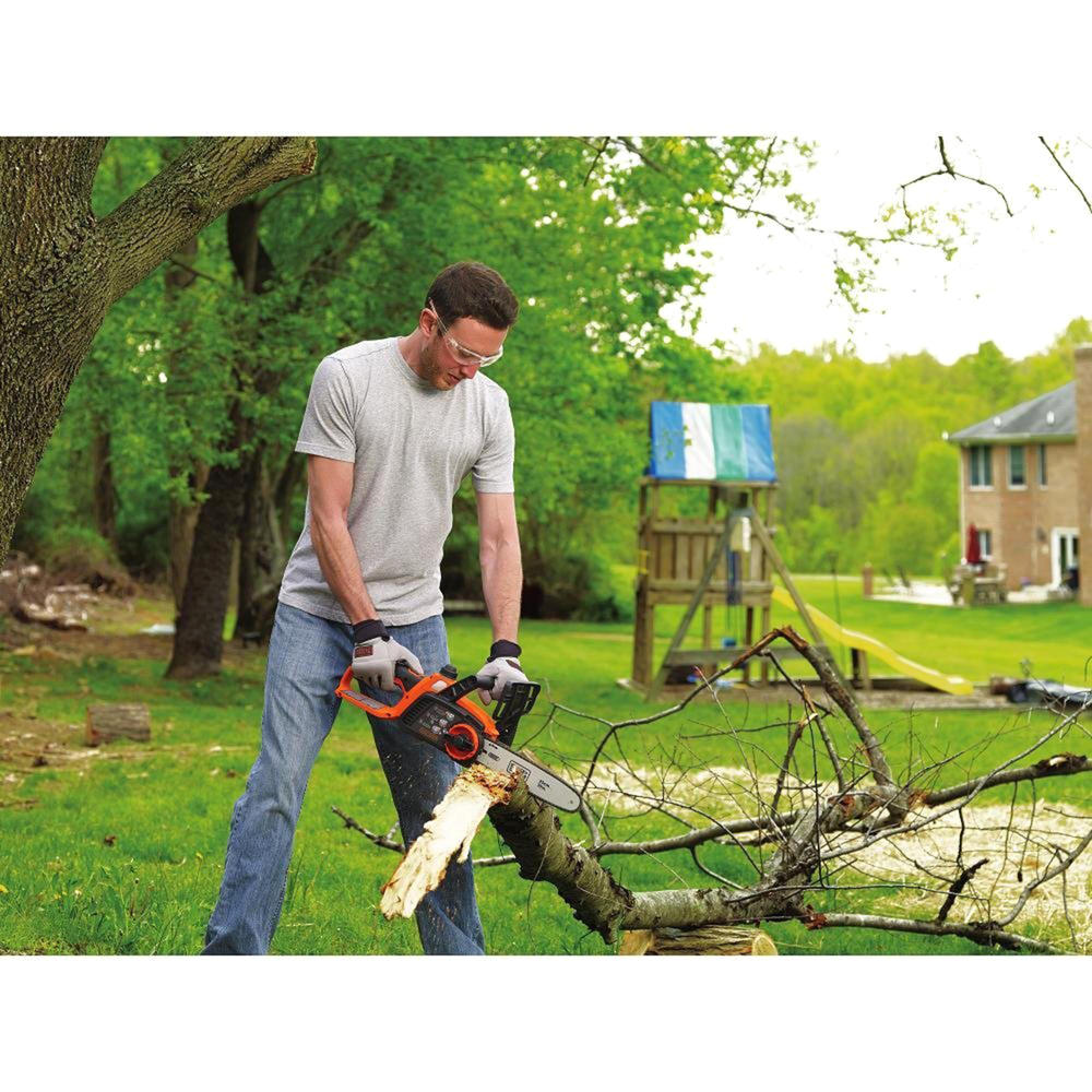 a man cutting a tree with a mini chainsaw